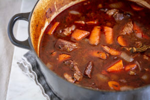 Guinness Beef Stew with mashed potatoes in a black le creuset pot