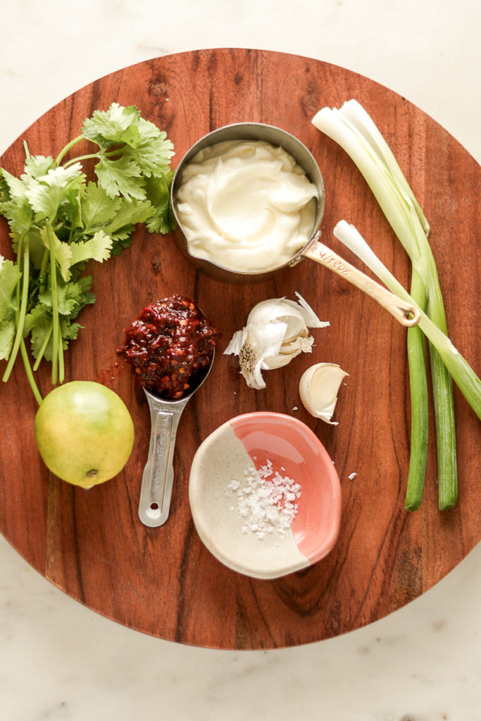 chipotle sauce ingredients on a board, mayo, chipotle, garlic lime and cilantro