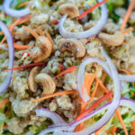 Close up overhead shot of Chicken Larb Napa Salad in a bowl with red onions