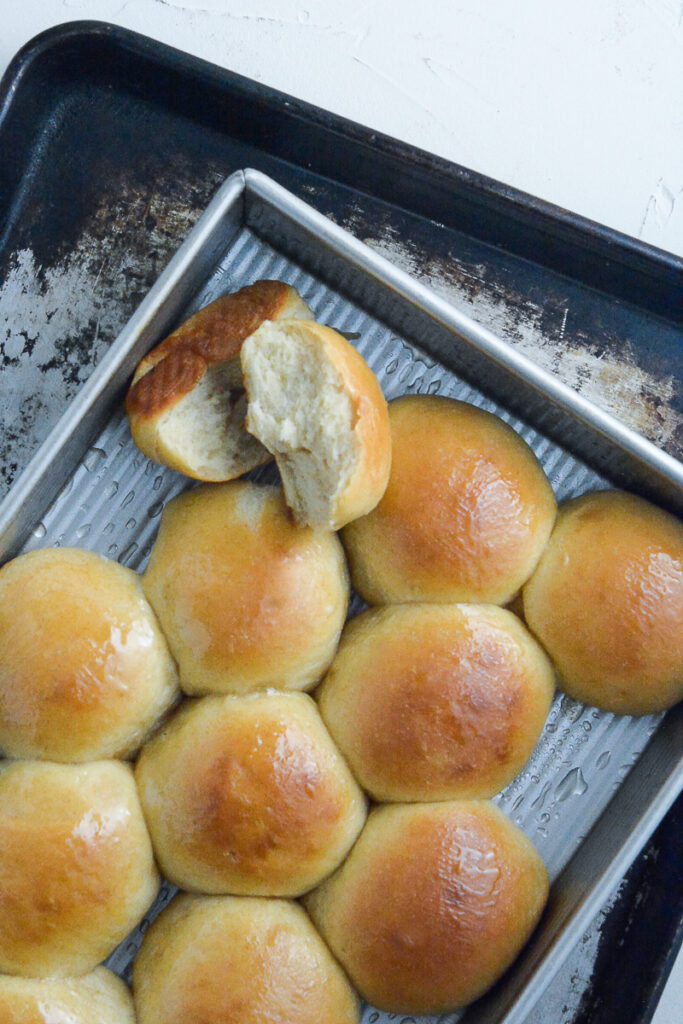 dinner rolls in pan with one split in half