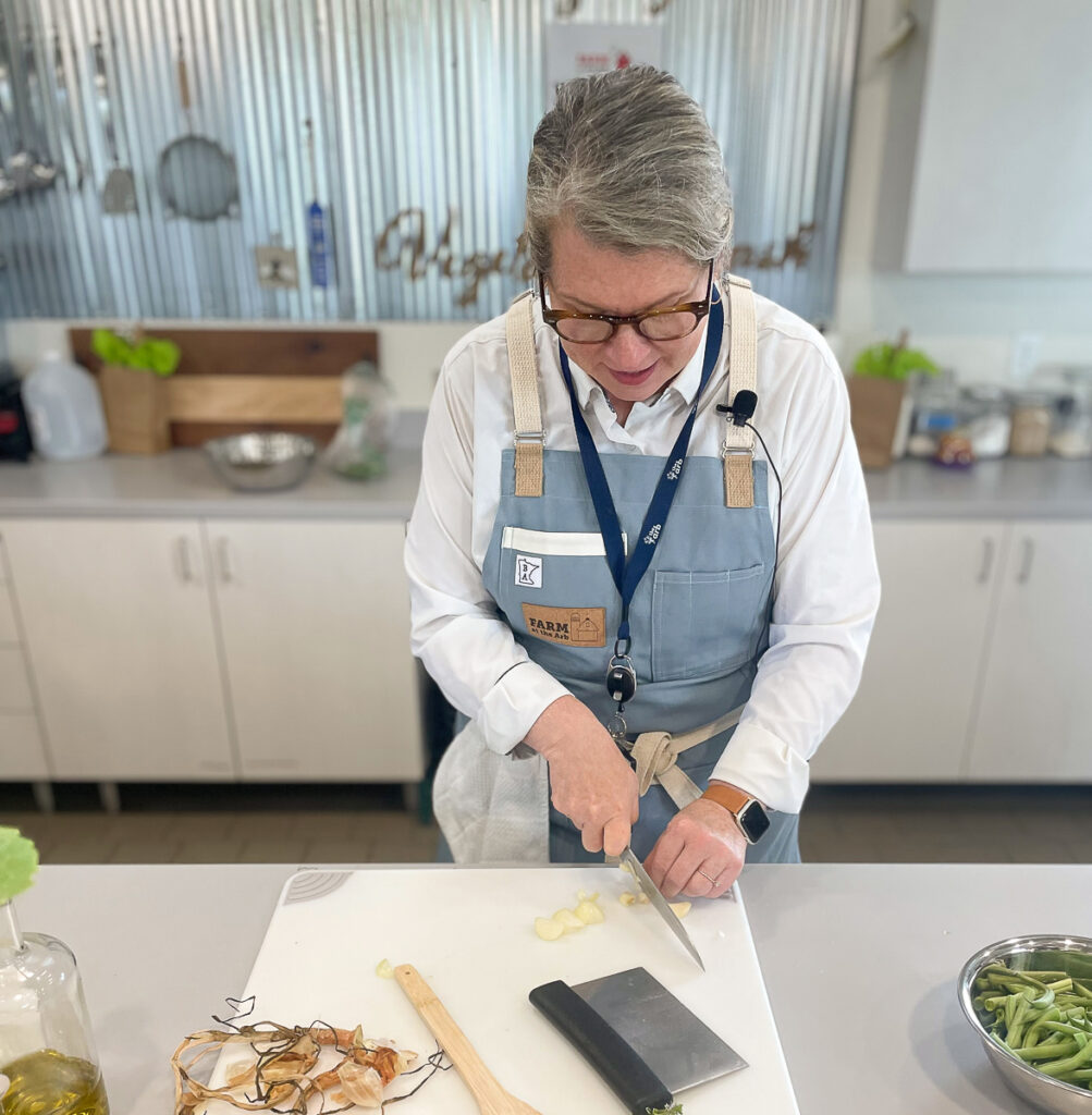 shelagh chopping shallots at the myers education kitchen at Farm at the Arb